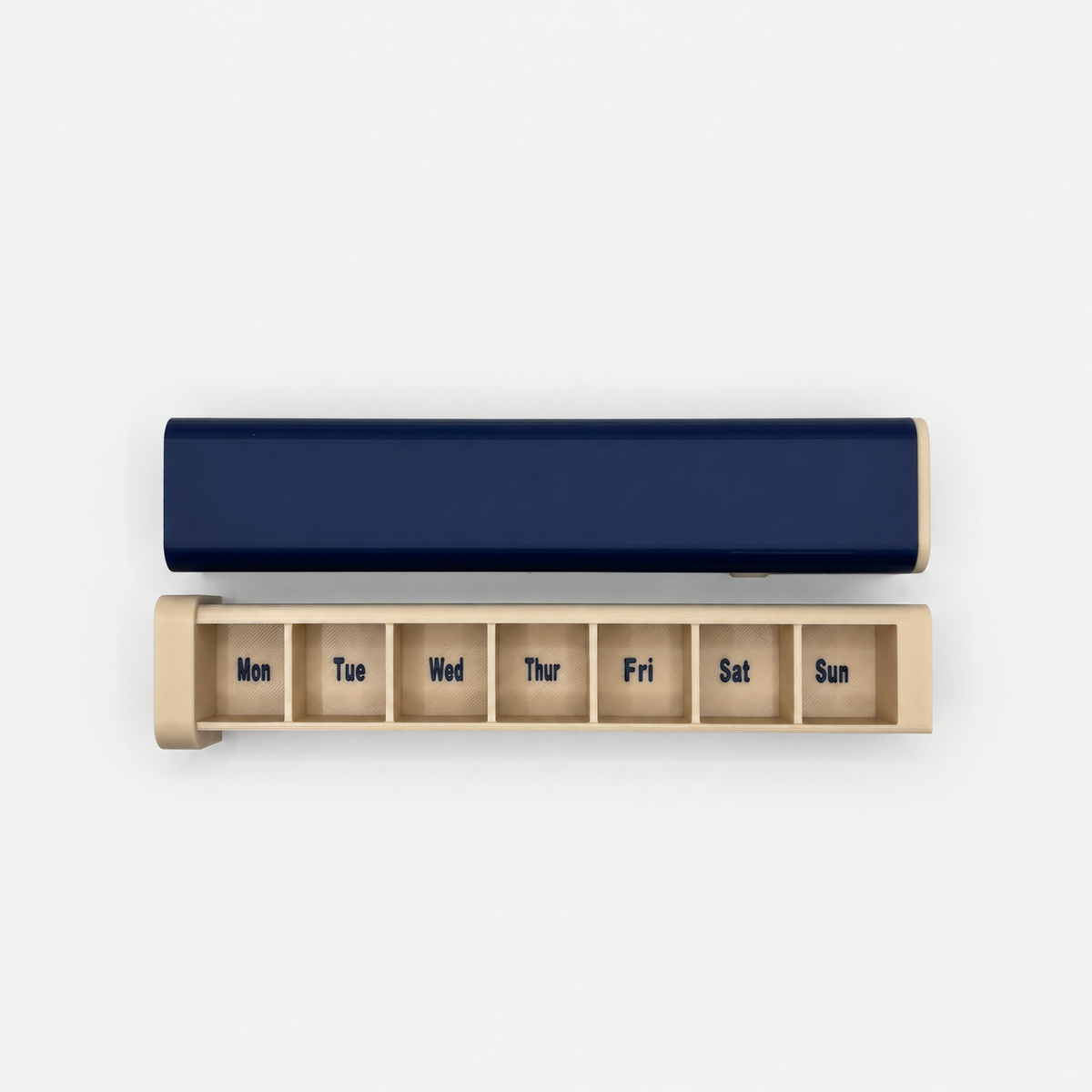 Navy and cream 7-day pill organizer with tray separated and Monday through Sunday compartments visible
